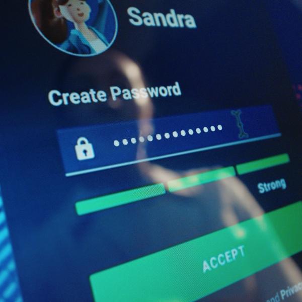 Close-up of a computer screen showing a password creation page with a username Sandra, bullet points, and strong password indicator.
